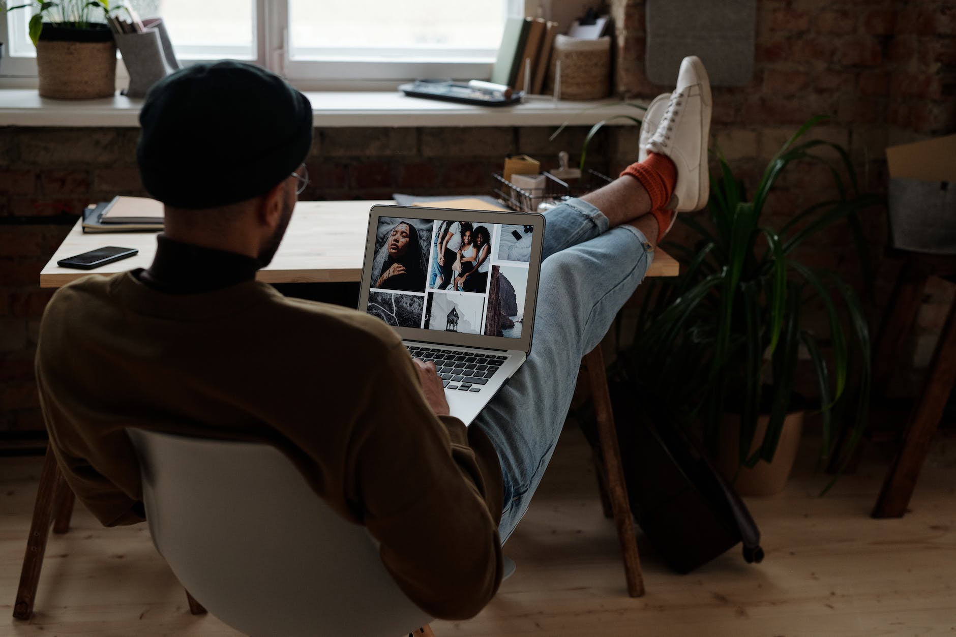 man in brown sweater sitting on chair using laptop